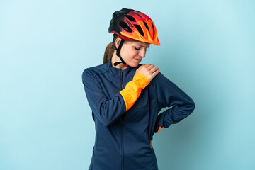 Young cyclist woman isolated on blue background suffering from pain in shoulder for having made an effort