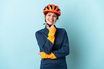Young cyclist woman isolated on blue background happy and smiling - obrazy, fototapety, plakaty