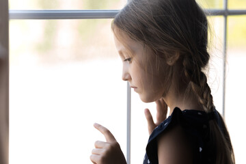 Depressed orphan kid looking out window, feeling lonely, coping with trauma, suffering from autism....