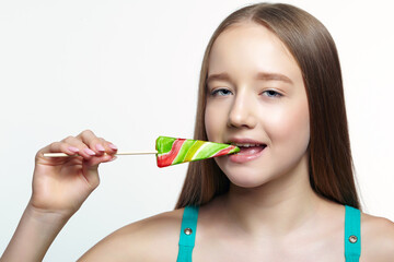 Teenager girl bites the lollipop. Sweet tooth concept