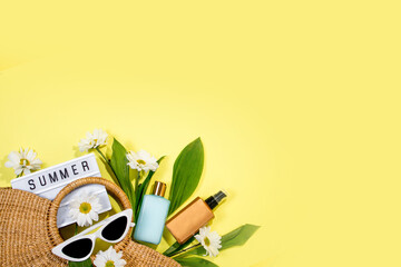 beach bag with beach accessories on a colored background top view. Sunscreen, glasses