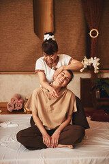 Qualified masseuse leaning head of glad woman to left