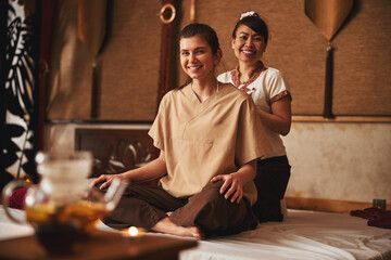 Thai massagist and her patient smiling to camera