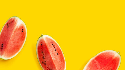 Watermelon slices on yellow surface with copy space