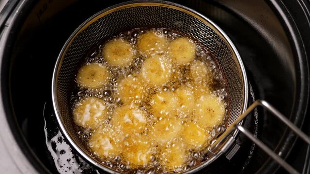 Cooking fried bananas in fryer fat. Closeup