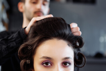 Fototapeta premium Stylist to make a hairstyle in the style of the 80's. Laying. hair.