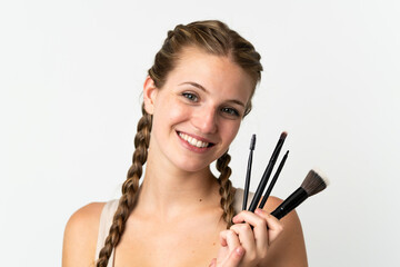 Young caucasian woman isolated on white background holding makeup brush and whit happy expression