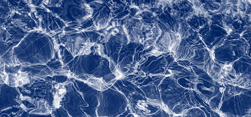 Water in swimming pool with sun reflection