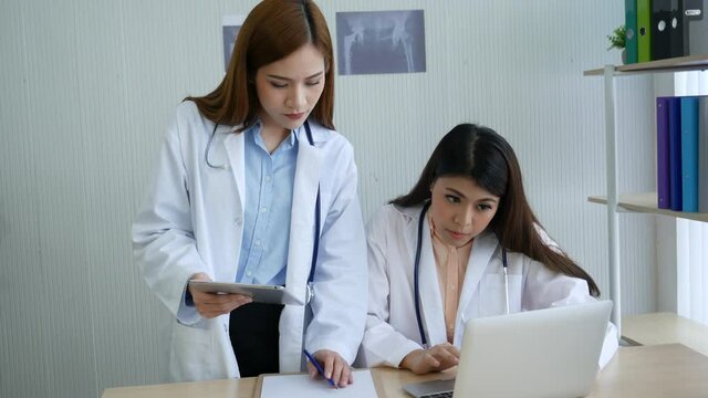 Doctor writing prescription for medical health care oncologist therapy using laptop. Two women doctors consultation with professional specialist diagnostics at hospital medicare treatment clinic