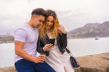 Fototapeta premium Lifestyle of a couple touring and enjoying the holidays. Looking at the mobile phone