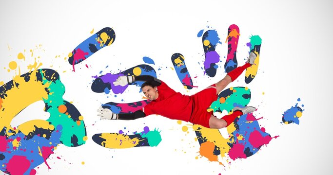 Composition of football goalkeeper over colourful handprints on white background
