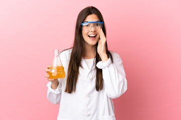 Young scientific girl over isolated pink background shouting with mouth wide open