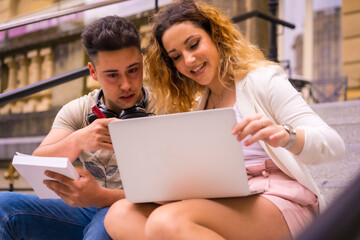 Young entrepreneurs doing teamwork. Working on the internet with the computer, boy with music headphones