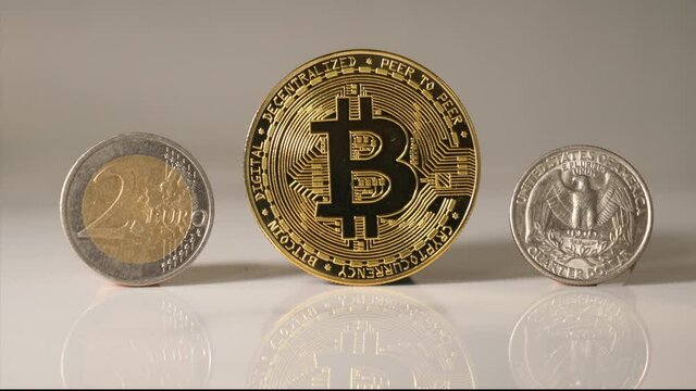 Golden bitcoin flanked by euro and US quarter coin. 