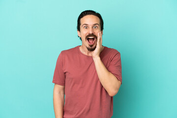 Young caucasian man isolated on blue background with surprise and shocked facial expression