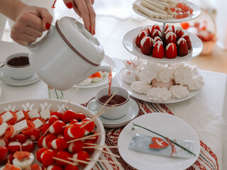 Beautifully served table with breakfast in white and red colors.