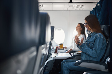 Woman cheering at information received on her laptop during flight