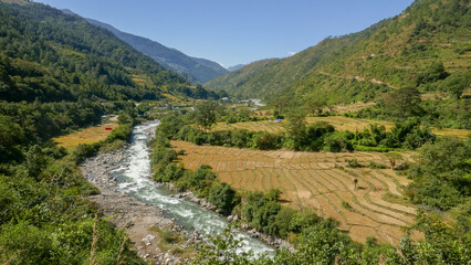 Fototapeta na wymiar Rural landscape panorama in the picturesque valley of Gamri Chu river with rice fields and forest, Trashigang, eastern Bhutan
