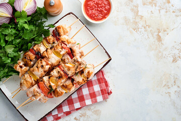 Chicken shish kebab or skewers kebab in a ceramic plate, spices, cilantro herbs and vegetables on white table background. Barbecue Raw ingredients for goulash or shish kebab. Top view. Free copy space