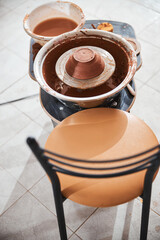 Empty chair staying in front of pottery wheel
