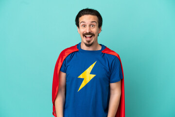 Super Hero caucasian man isolated on blue background with surprise facial expression