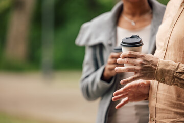 Coffee being held by an adult couple.