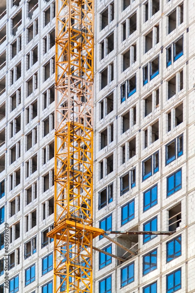 Poster close up view of frame part of metallic crane machinery attachment at windows of new residential bui