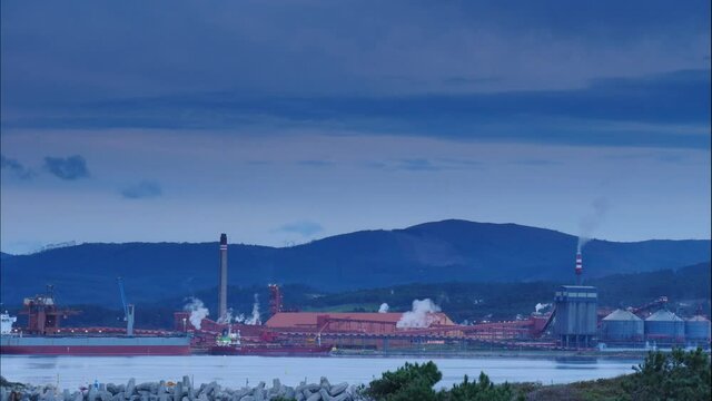 Time lapse of clouds moving over industrial area on sea coast. Fabrica de Alumina Alcoa in Galicia Spain. Aluminum industry.