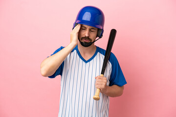 Young caucasian man playing baseball isolated on pink background with headache