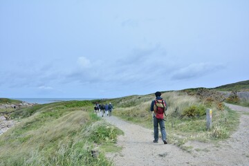 Fototapeta premium group of senior hikers on the path at Landrellec in Brittany. France