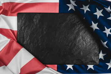 Black stone plaque on the American flag with place for text.