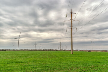 Fototapeta na wymiar Wind turbines generating electricity in a green field. Green power generation concept.