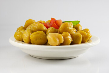 A dish of cooked chickpeas or garbanzo on white background.