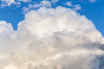 Big white fluffy cumulus cloud against blue sky background, cloud abstract texture, thunderstorm	