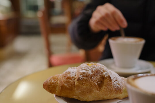 Italian breakfast with croissant and coffee at the cafe. Selective focus