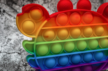 Touch popit toy on an abstract background. The color of the rainbow. Antistress toy for children and adults. Close-up.