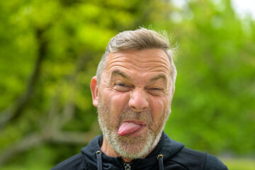 Head shot of a middle-aged man stick out tongue