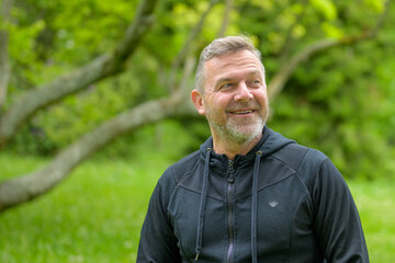 Man smiling happily as he enjoys a day in the park in spring