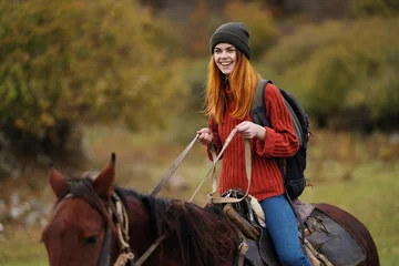 Foto op Canvas cheerful woman hiker ride a horse fun travel mountains © SHOTPRIME STUDIO
