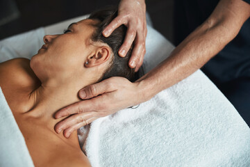 Fototapeta na wymiar Male masseur healing body treatment of female patient in health center