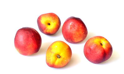 five nectarines lie on a white background