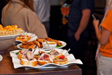 Sandwiches with meat on a white plate. Sandwiches with ham and olives close up.