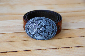 Leather cowboy belt on wooden background