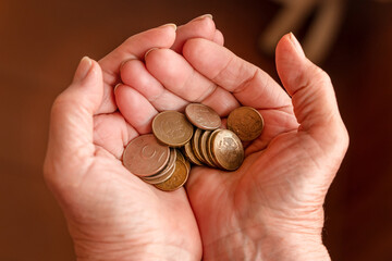 The hand of an elderly woman holding Russian coins. The concept of saving money, pensions, and helping the elderly.