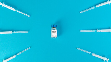 Coronavirus vaccine vials. Covid-19 vaccination with vaccine ampoules and syringes. Vaccine against the pandemic. Blue background. Stop Covid concept. Clinical trial.