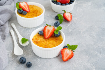 Creme brulee. Traditional French vanilla cream dessert with caramelised sugar and fresh berries on top.
