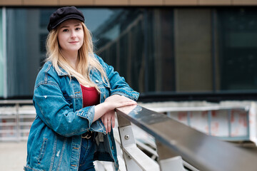 Portrait of young woman leaning on a bridge banister.