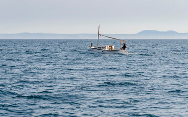 Barca tradicional tipo  menorquina navegando por la bah&iacute;a de Rosas en el mar Mediterraneo de la Costa Brava, Catalu&ntilde;a, Espa&ntilde;a
