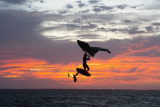 Pro surfer James Jenkins jumps his wing surfer at sunset over the Pamlico Sound at Nags Head, North Carolina