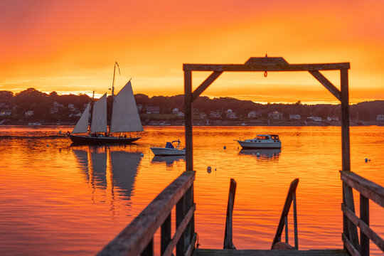 A schooner returns to dock at sunset at Bailey Island, Casco Bay, Maine